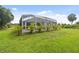Enclosed screened in pool area bordered with vibrant palm trees, set within a beautifully maintained lawn at 2511 Stagnaro Rd, North Port, FL 34287