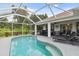 Screened-in pool and patio area offering a serene outdoor living space with lush landscaping at 2511 Stagnaro Rd, North Port, FL 34287