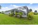Enclosed screened in pool area bordered with vibrant tropical plants, set within a beautifully maintained lawn at 2511 Stagnaro Rd, North Port, FL 34287