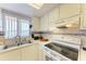 Clean kitchen featuring white cabinets and a double sink at 4159 Heron Way # E303, Bradenton, FL 34205