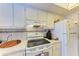 Well-equipped kitchen boasts white cabinets, electric range, and a refrigerator at 4159 Heron Way # E303, Bradenton, FL 34205