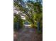 Long driveway leading to a charming two-story home with lush landscaping at 655 N Clermont Rd, Venice, FL 34292
