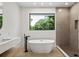 Modern bathroom with freestanding tub, walk-in shower, and window at 1734 Wisconsin Ln, Sarasota, FL 34239