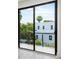 Sliding glass door leading to a balcony overlooking trees and houses at 1734 Wisconsin Ln, Sarasota, FL 34239