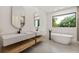 Spa-like bathroom with double vanity, soaking tub, and large window at 1734 Wisconsin Ln, Sarasota, FL 34239