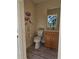 Half-bath featuring modern toilet, wooden vanity, decorative wall art and a well-lit mirror at 15 Tee View Pl, Rotonda West, FL 33947