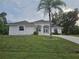 Charming single-story home with a well-maintained lawn and a beautiful palm tree in the front yard at 15 Tee View Pl, Rotonda West, FL 33947