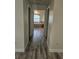 Hallway view featuring luxury vinyl floors and a glimpse into the bathroom with a soaking tub at 15 Tee View Pl, Rotonda West, FL 33947