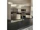 Well-lit kitchen featuring stainless steel appliances, white cabinets, and dark countertops for a modern look at 15 Tee View Pl, Rotonda West, FL 33947
