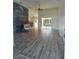 Bright living room with wood-look floors, decorative accent wall, and sliding glass doors to the pool area at 15 Tee View Pl, Rotonda West, FL 33947