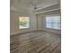 Spacious main bedroom featuring tray ceiling, fan, luxury vinyl floors, and abundant natural light at 15 Tee View Pl, Rotonda West, FL 33947