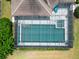 Aerial view of a screened-in pool with surrounding greenery and a tile roof at 7249 Orchid Island Pl, Bradenton, FL 34202