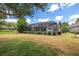 Expansive backyard featuring a screened-in pool enclosure, mature trees, and meticulously maintained landscaping at 7249 Orchid Island Pl, Bradenton, FL 34202