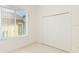 This bedroom features neutral walls, carpeted floors, closet, and a view from large window at 7249 Orchid Island Pl, Bradenton, FL 34202