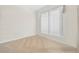 This is a bright bedroom with white walls, carpeted floors, and a view from a large window at 7249 Orchid Island Pl, Bradenton, FL 34202
