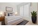 This bedroom features neutral walls, carpeted floors, nightstands, lamps, and a view from large window at 7249 Orchid Island Pl, Bradenton, FL 34202