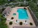 Aerial view of a community pool with palm trees, chairs, umbrellas and cabana at 7249 Orchid Island Pl, Bradenton, FL 34202
