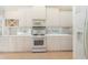 Bright kitchen with white cabinets, a gas range, and tile backsplash at 7249 Orchid Island Pl, Bradenton, FL 34202
