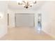 Bright living room with modern chandelier and neutral tile flooring at 7249 Orchid Island Pl, Bradenton, FL 34202