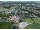 Aerial view of pickleball courts, parking, and golf course near lush landscaping at 7249 Orchid Island Pl, Bradenton, FL 34202