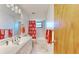 Clean bathroom with white vanity, coral shower curtain, and tiled walls at 1415 Piedmont Rd, Venice, FL 34293
