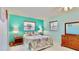 A bedroom featuring turquoise walls, tropical bedding, and wood furnishings at 1415 Piedmont Rd, Venice, FL 34293