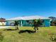 Charming light blue house with a white roof, landscaping, and a two-car garage at 1415 Piedmont Rd, Venice, FL 34293