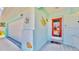 Charming front entrance with a red door, decorative fish, and a white garage door at 1415 Piedmont Rd, Venice, FL 34293