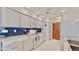 Bright kitchen featuring white cabinets, modern appliances, and a blue subway tile backsplash at 1415 Piedmont Rd, Venice, FL 34293