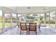 Enclosed sunroom with ample windows, tile flooring, and a glass table with chairs at 1415 Piedmont Rd, Venice, FL 34293
