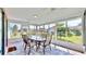 Enclosed sunroom with ample windows, tile flooring, and a glass table with chairs at 1415 Piedmont Rd, Venice, FL 34293