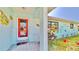 Welcoming front entry with a unique coral door and whimsical fish decor at 1415 Piedmont Rd, Venice, FL 34293