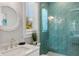Stylish bathroom featuring a glass enclosed shower with unique aqua tile and white vanity at 149 Mckinley Dr, Sarasota, FL 34236