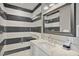 Contemporary bathroom with striking black and white tile, a glass shower, and a marble countertop at 149 Mckinley Dr, Sarasota, FL 34236