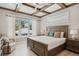 Cozy bedroom featuring a wood-framed bed, wood-beamed ceilings, and a serene window view at 149 Mckinley Dr, Sarasota, FL 34236