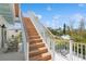 Exterior shot of wooden staircase with white railings overlooking surrounding neighborhood and clear skies at 149 Mckinley Dr, Sarasota, FL 34236