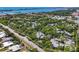 Aerial view of a community with lush landscaping, tennis courts, and water access at 207 Woodland Dr # 207, Osprey, FL 34229