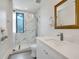 Modern bathroom with marble shower, white vanity, and gold mirror at 1542 4Th St # 212, Sarasota, FL 34236