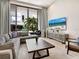 Bright living room with sectional sofa, large TV, and access to patio with pool view at 1542 4Th St # 212, Sarasota, FL 34236