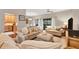 Comfortable living room with sofas, ottoman, and view into kitchen and dining areas at 207 Woodland Dr # 207, Osprey, FL 34229