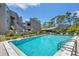 Community pool with lounge chairs and surrounding landscaping at 207 Woodland Dr # 207, Osprey, FL 34229
