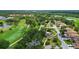 Aerial view of a community with houses, green spaces, and a golf course at 4440 Calle Serena, Sarasota, FL 34238
