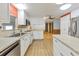 Kitchen features white cabinets, stainless steel appliances, and light wood flooring at 1508 45Th E Ave, Ellenton, FL 34222