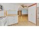 Open kitchen with white cabinets, light wood flooring, and access to living area at 1508 45Th E Ave, Ellenton, FL 34222