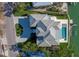 Aerial view showcasing the home's unique roof design, pool, driveway, and waterfront access at 3550 Flamingo Ave, Sarasota, FL 34242