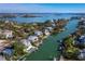 Picturesque aerial view of waterfront homes along a canal, showcasing docks and lush landscaping under a clear sky at 3550 Flamingo Ave, Sarasota, FL 34242