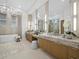Luxurious bathroom featuring a modern vanity with marble countertop, elegant lighting, and large mirrors at 3550 Flamingo Ave, Sarasota, FL 34242