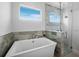 A contemporary bathroom features a standalone tub, separate glass shower, and serene blue and gray tiling for a spa-like ambiance at 3550 Flamingo Ave, Sarasota, FL 34242