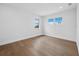 Empty bedroom with hardwood floors, neutral walls, and natural light from two windows at 3550 Flamingo Ave, Sarasota, FL 34242