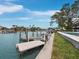 A waterfront view shows a dock and boat lift, with lush landscaping surrounding the property, close to the backyard pool at 3550 Flamingo Ave, Sarasota, FL 34242